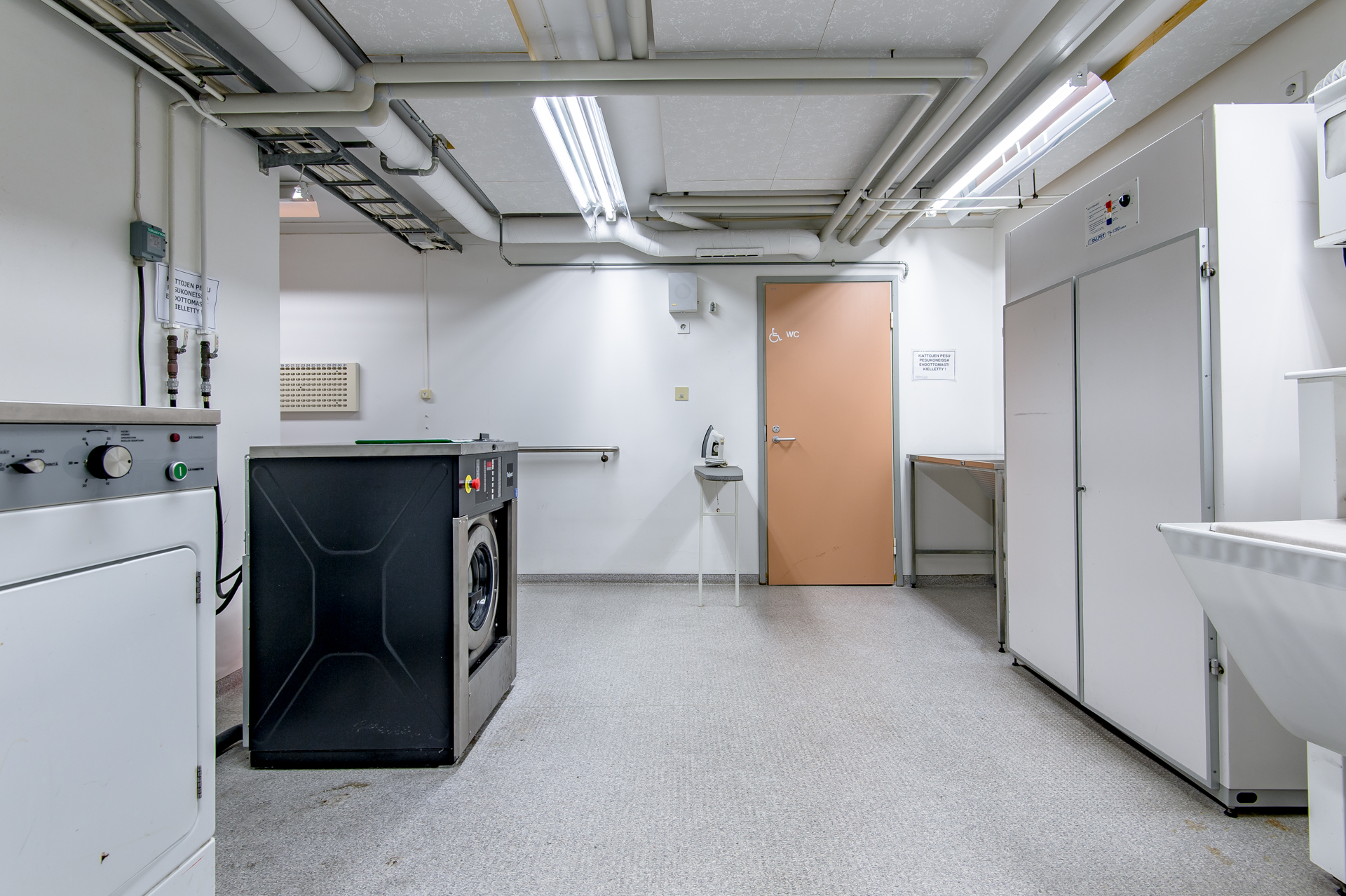 13Pesutupa jossa on pesukoneita ja kuivausrumpuja ja pesuallas